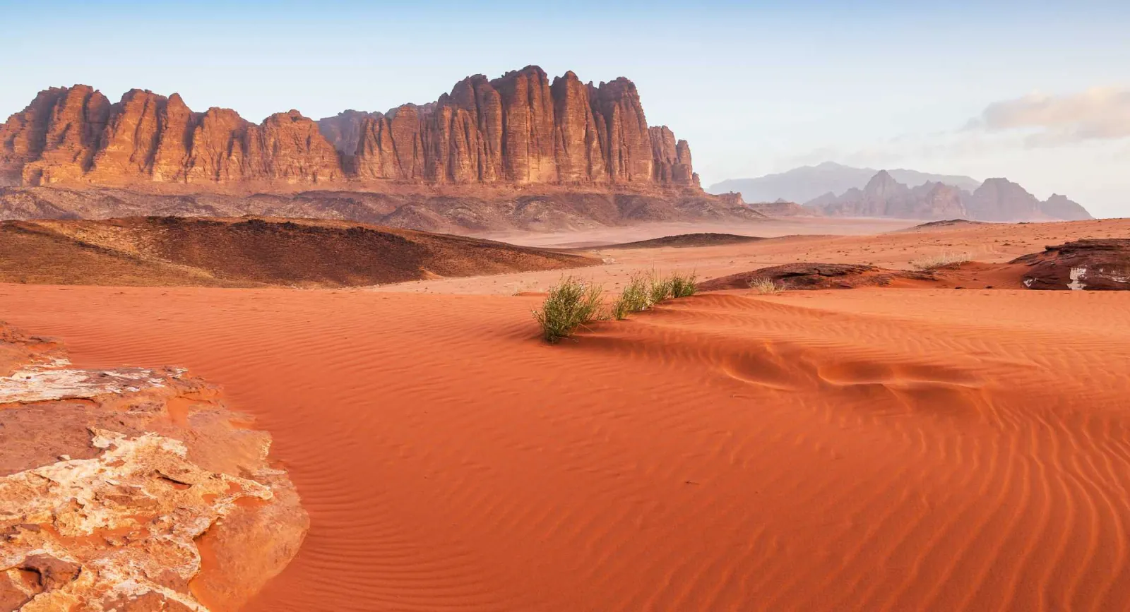 Red dunes running to the sandstone massifs of Wadi Rum