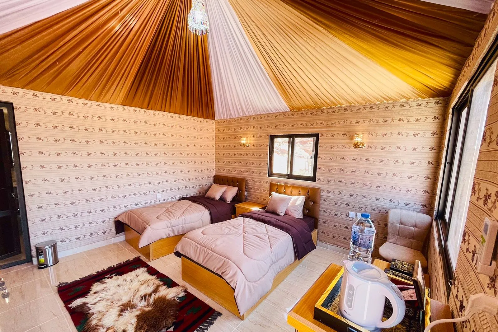 Twin beds and rugs inside a Bedouin camp tent in Wadi Rum