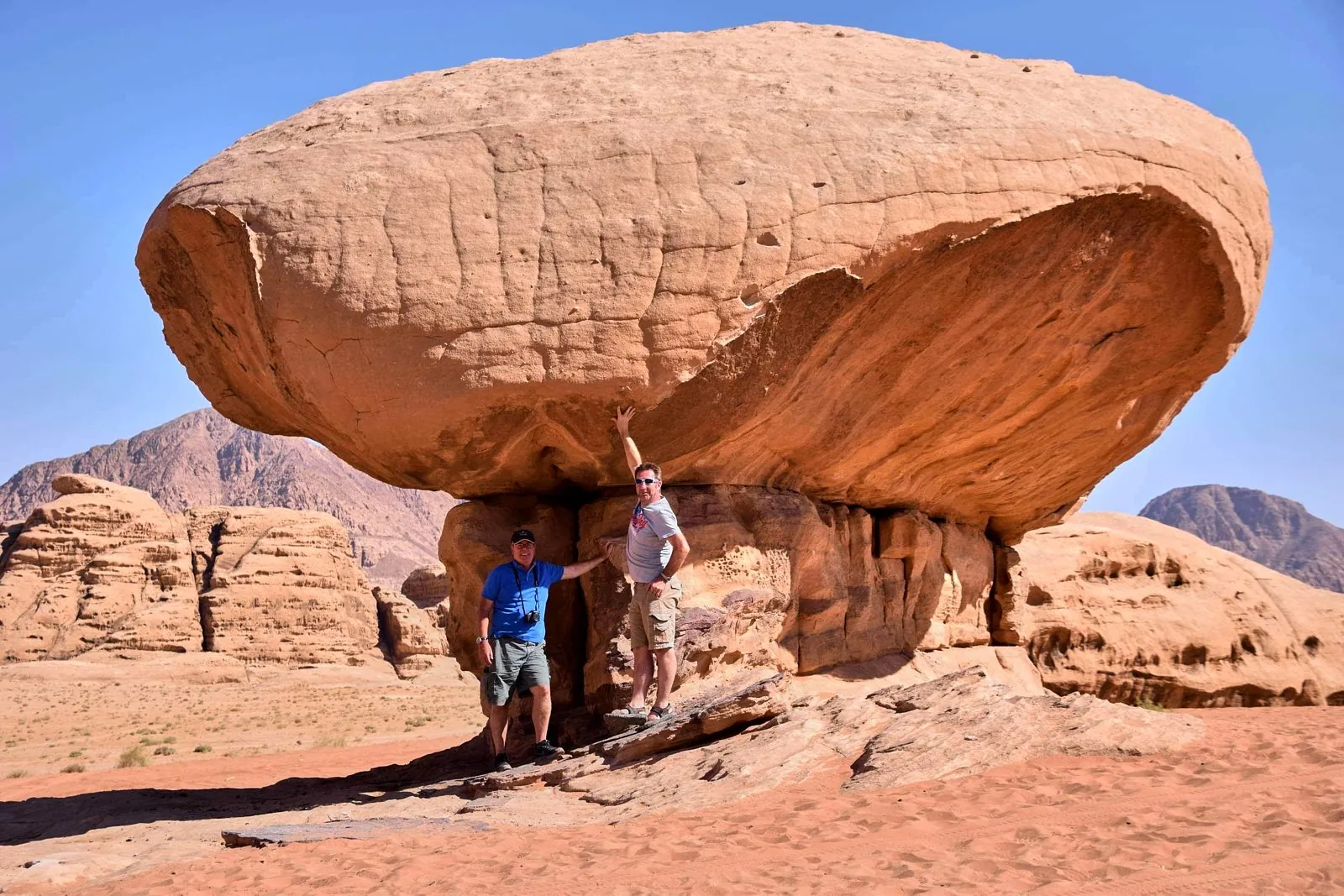 The wind-carved Mushroom Rock standing over the red sand of Wadi Rum