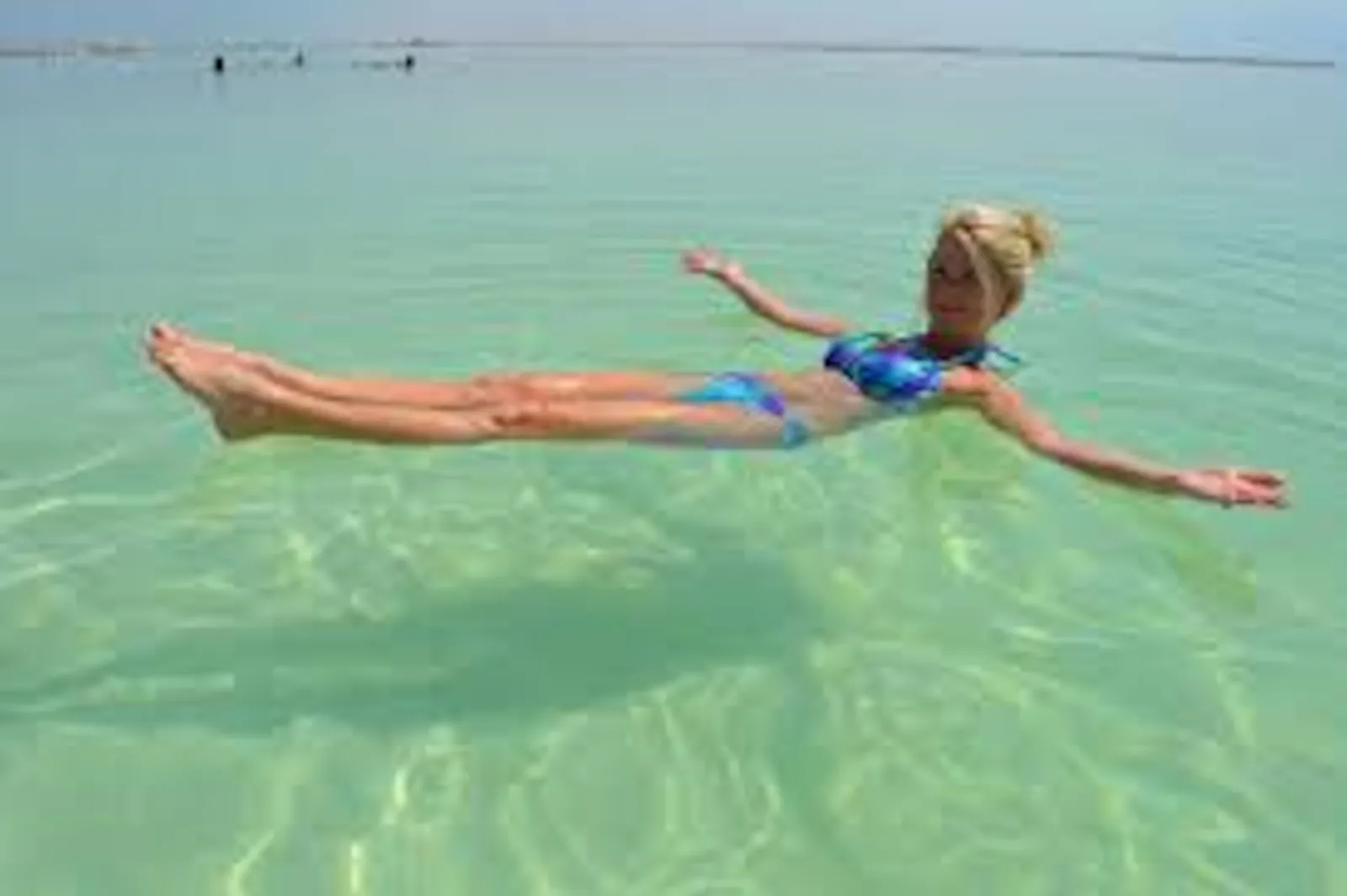 A swimmer floating flat on her back in the Dead Sea, no effort needed